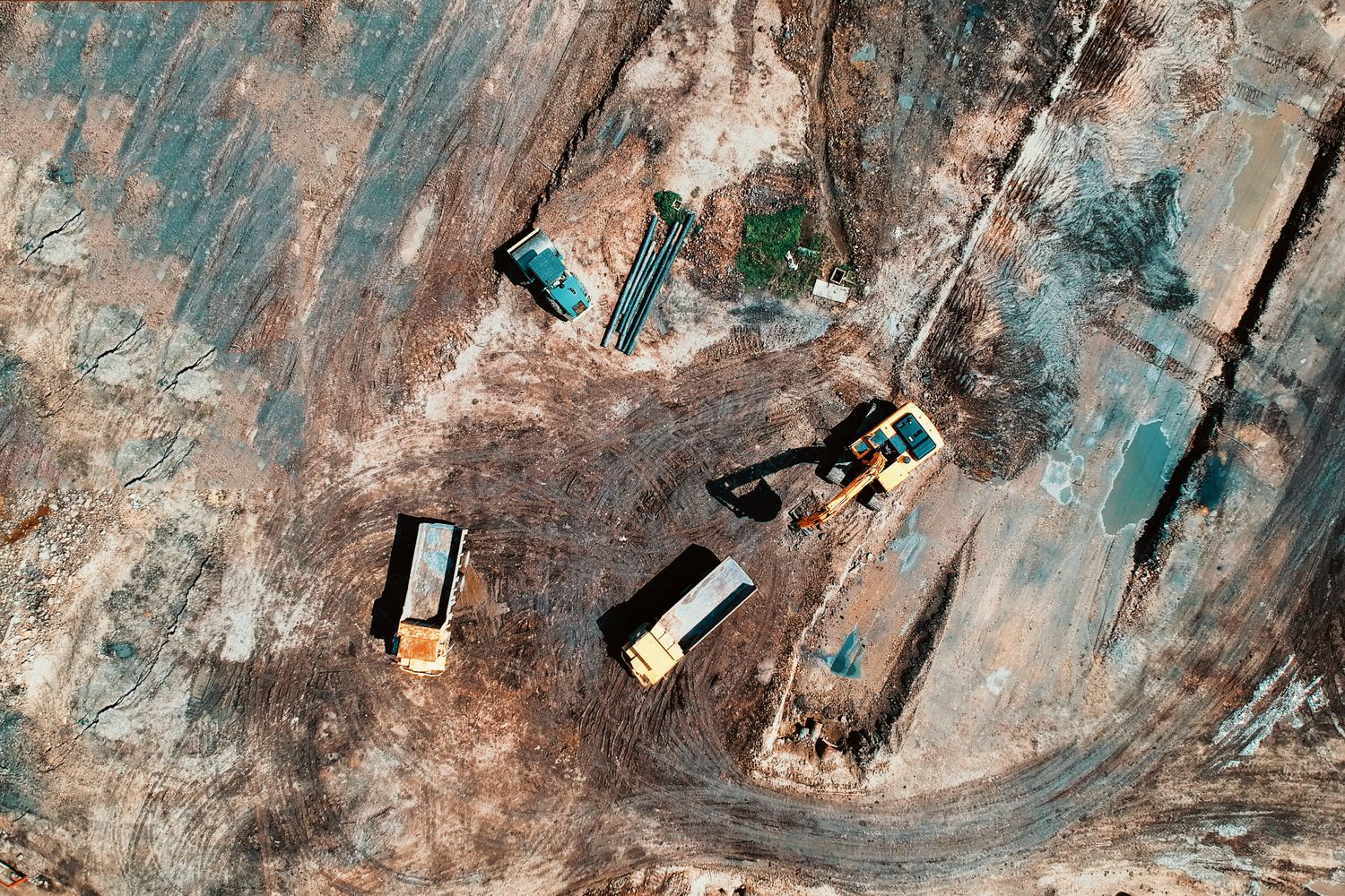 Aerial view of dump trucks and an excavator on site